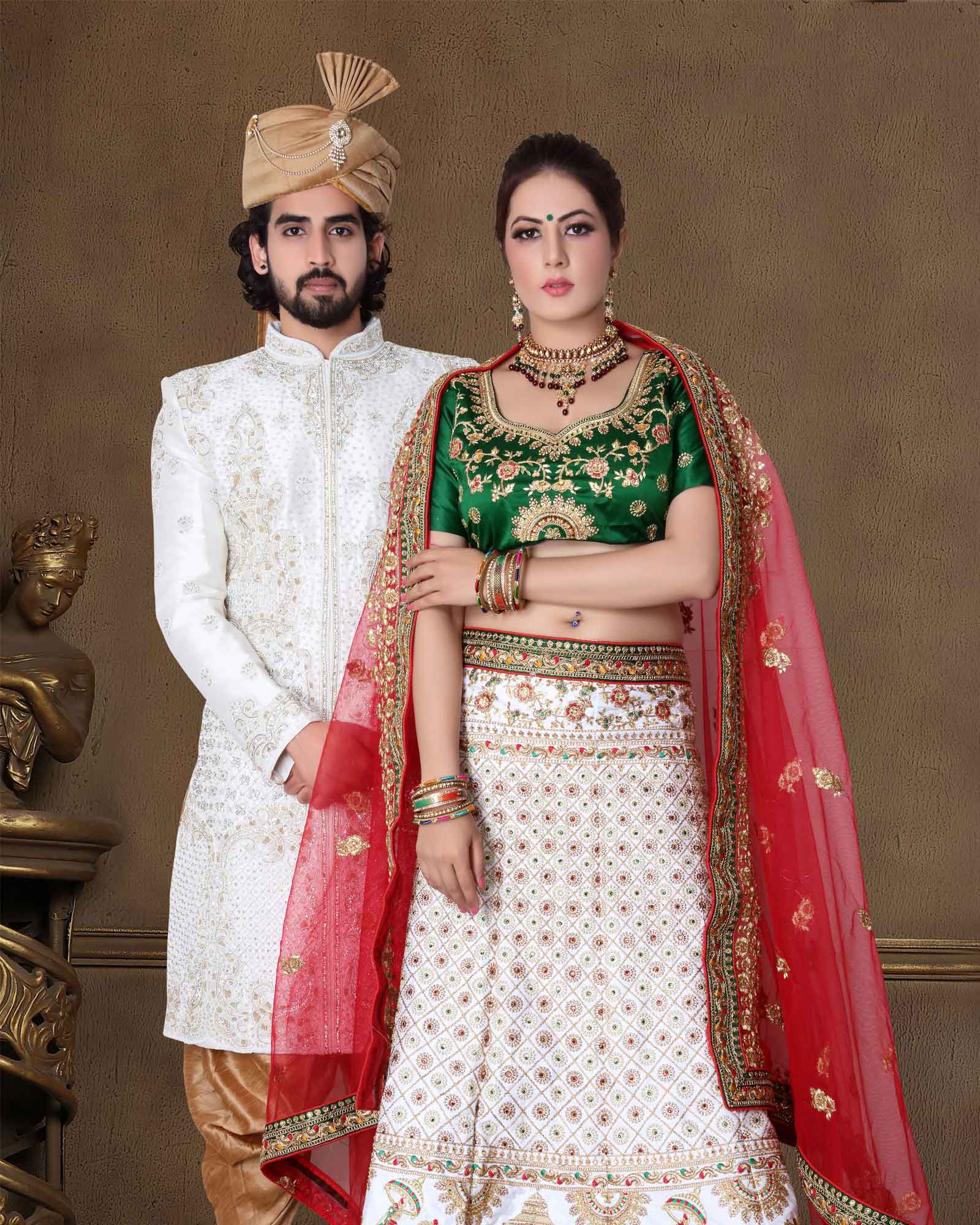 Indian groom dressed in Sherwani with stunning bride standing with  glamorous outfit and jewellery with makeup and hold each hand in a banquet  hall Stock Photo - Alamy